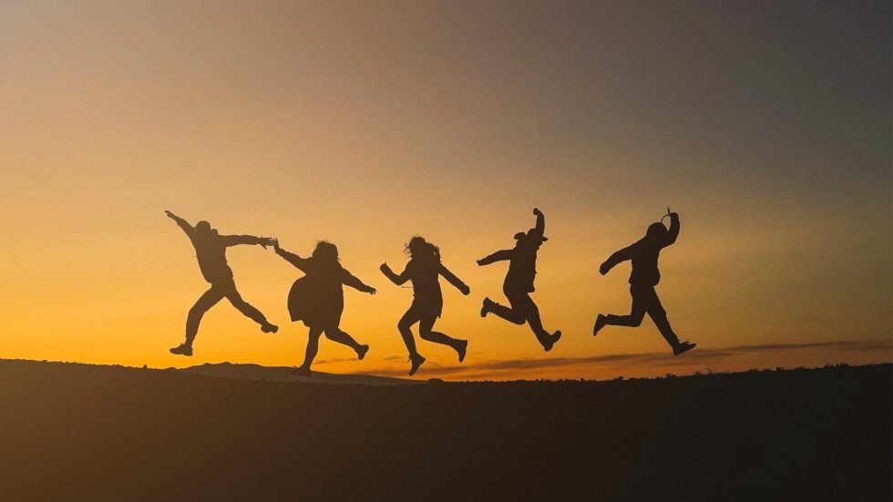 silhouette of 5 people jumping in the air