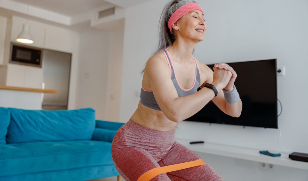 Woman using mini bands during an exercise in her home