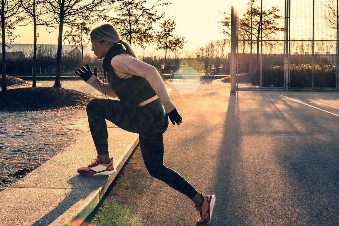 Woman doing step up exercises for glutes in park
