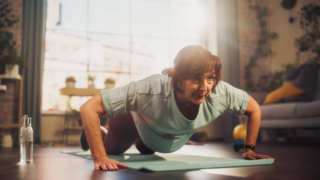 Woman doing burpees to burn fat during menopause