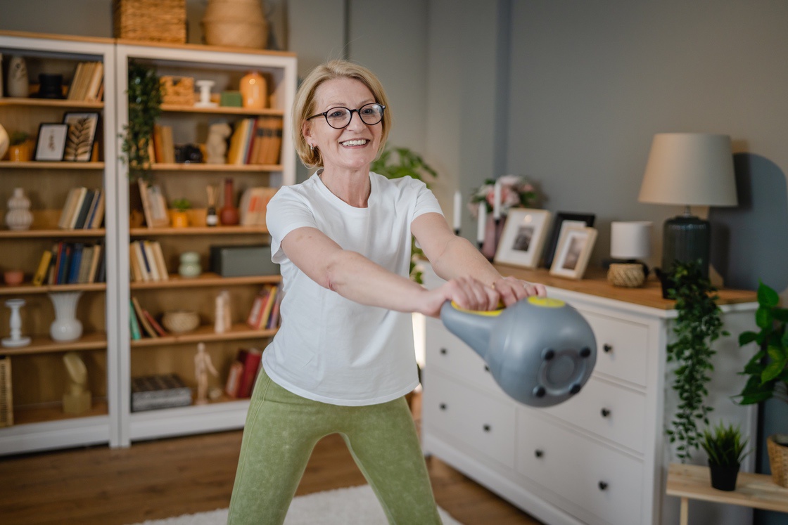 Woman doing kettlebell swing to burn fat during menopause
