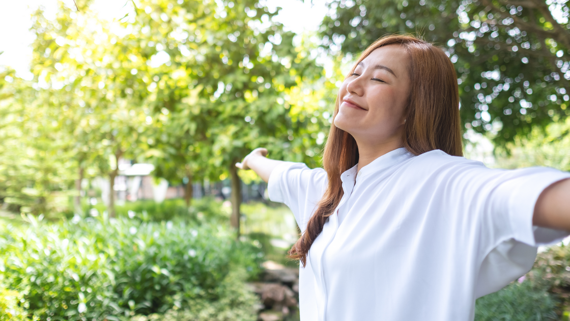 Woman smiling and happy in park with limited stress 